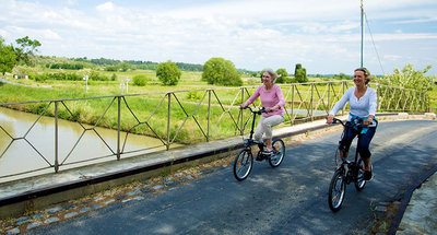 Due donne in bicicletta attraverso il ponte sul Canal du Midi